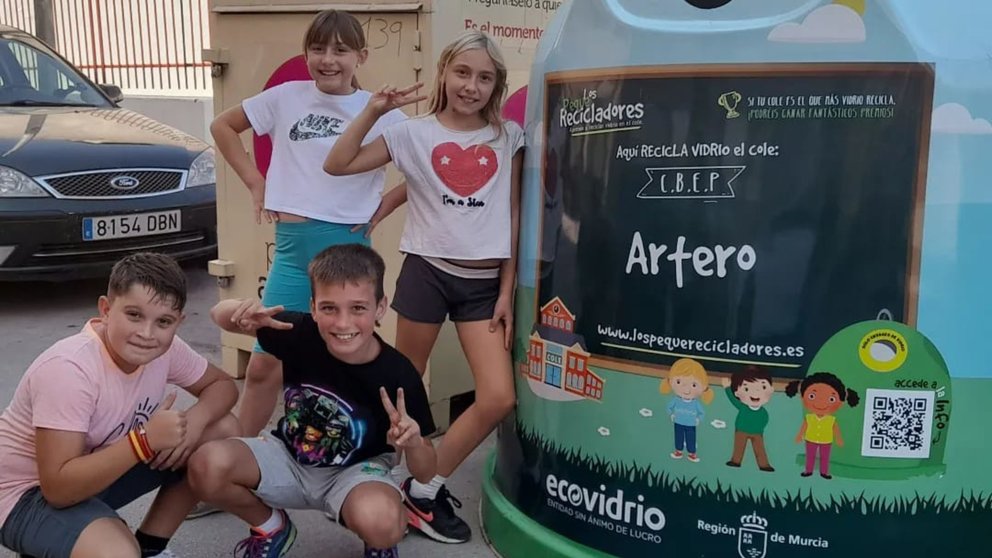 Alumnos de Primaria junto a un contenedor de vidrio durante la campaña 'Los Pequeños Recicladores'