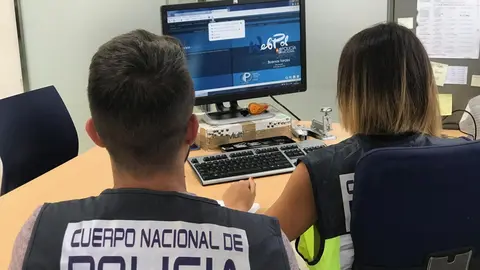 Agentes de la Polic&iacute;a Nacional delante de un ordenador