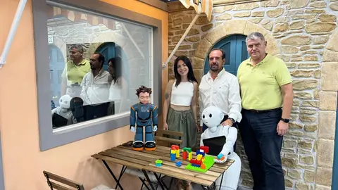 Gema Benedicto, Jos&eacute; Manuel Ferr&aacute;ndez y Eduardo Hurtado junto a los robots Milo y Pepper en el laboratorio que simula una cafeter&iacute;a